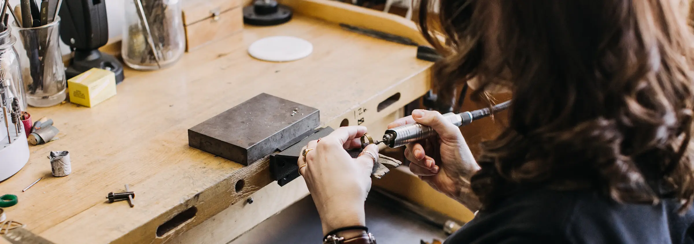 A woman works on a piece of jewelry