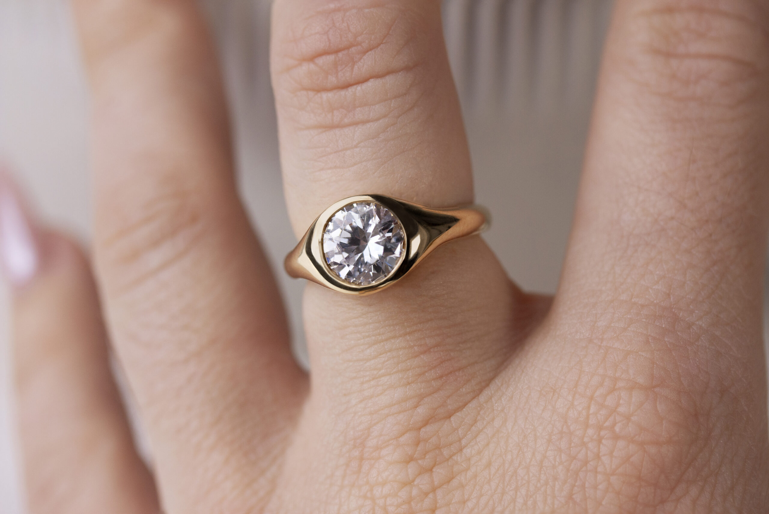 Gold signet ring by Philadelphia's Emily Chelsea Jewelry, featuring soft curves and a flush-set white diamond.