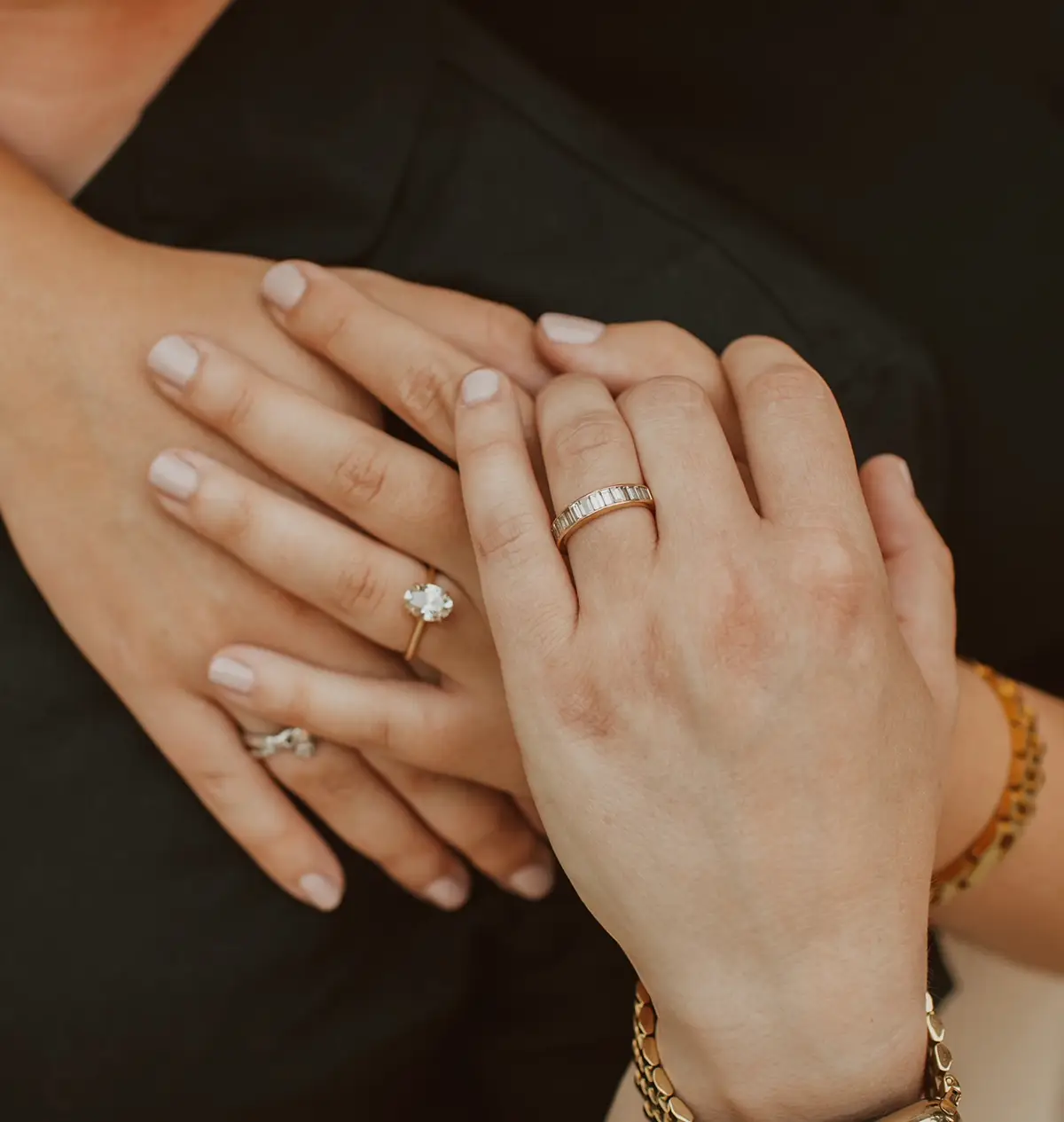 A couple hold hands while showing off their rings
