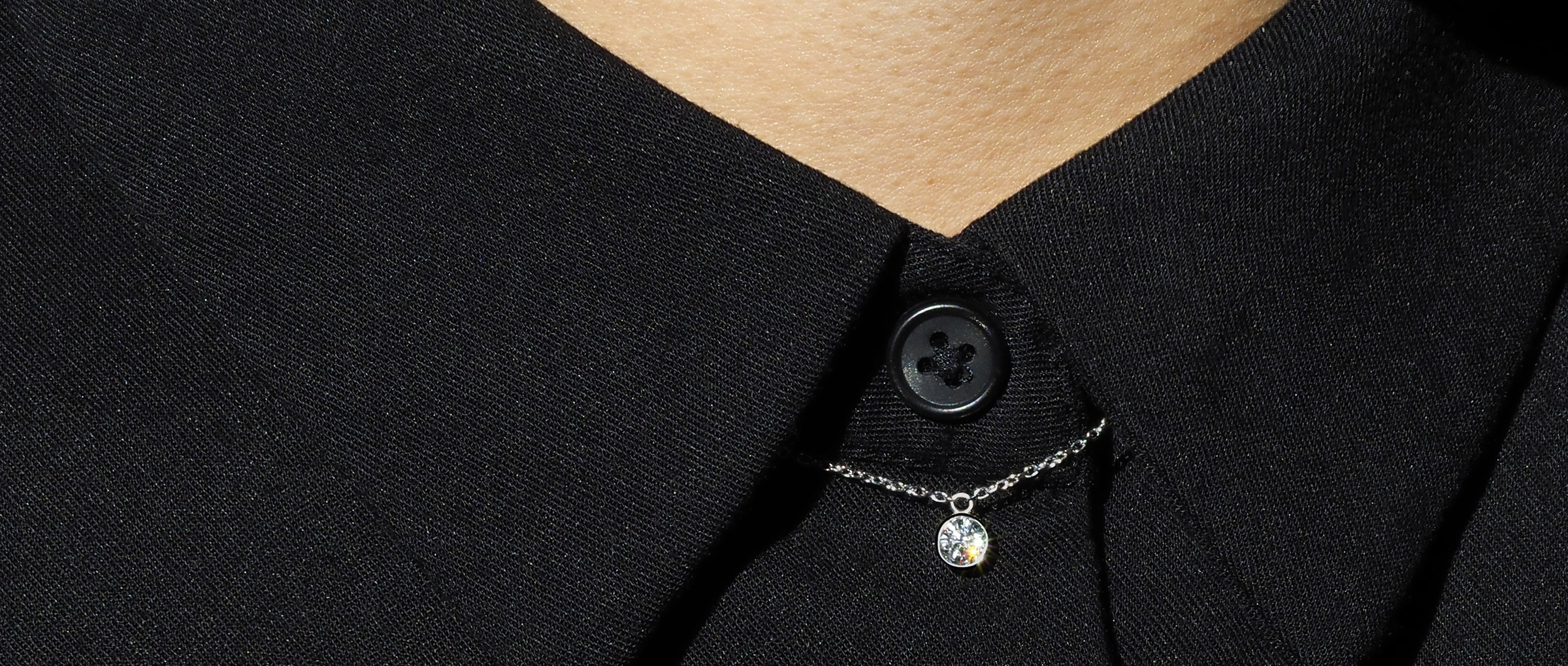 A necklace on toe of a black shirt